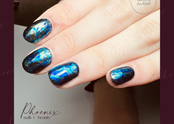 Petrol blue gel polish nails with foil to give an oil slick effect on long natural nails